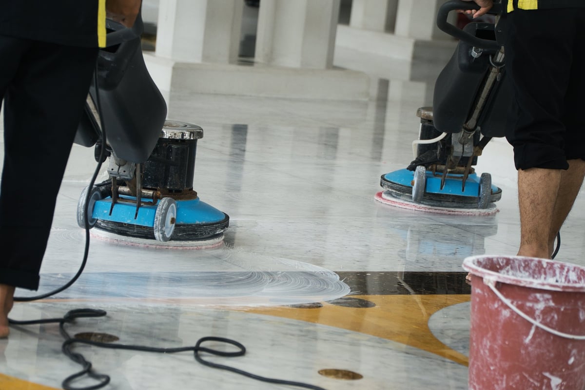 Marble and grout technicians operating buffing machines over a polished marble floor in an Arizona resort lobby, restoring its depth and gloss dust-free