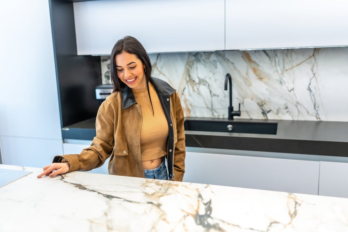 Person selecting a marble countertop in a modern showroom