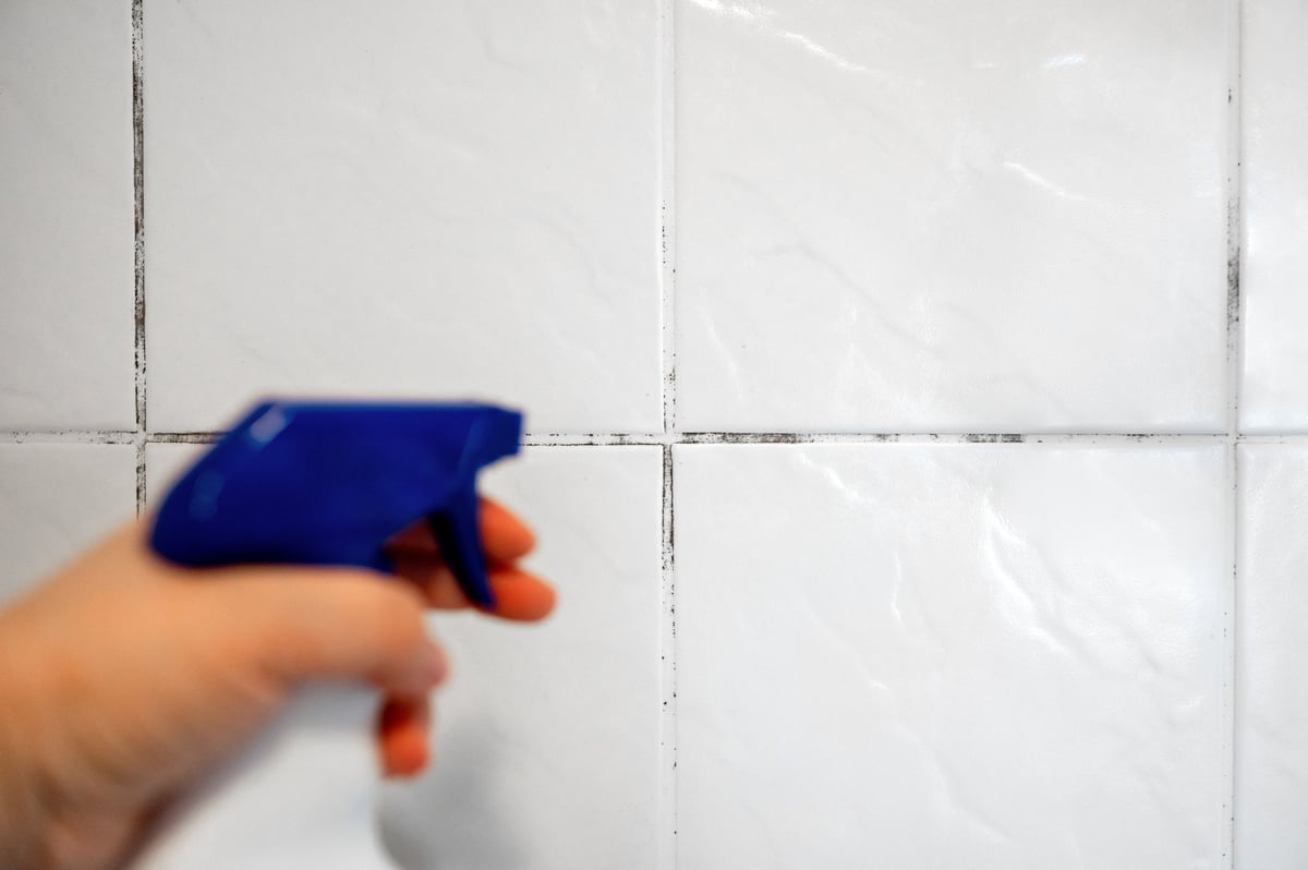 Applying a protective sealant to seams in a bathroom to prevent mold and staining