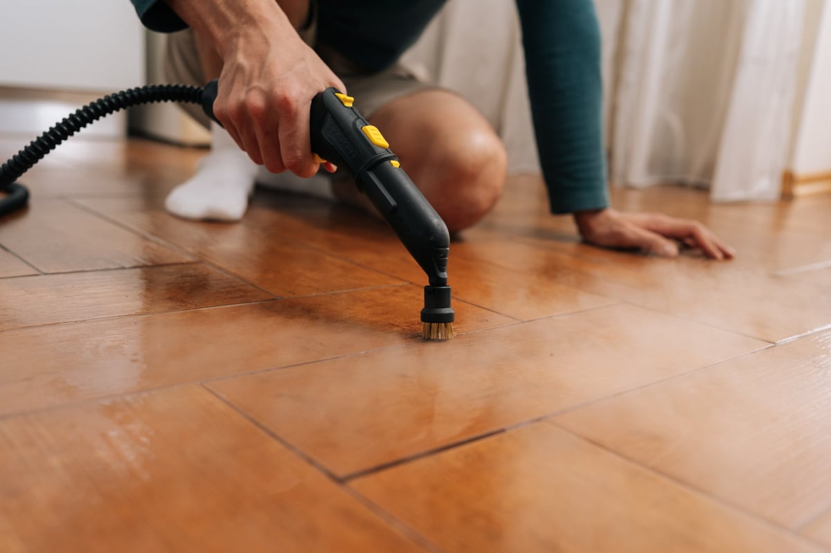 Deep cleaning flooring with a steam cleaner targeting grout lines